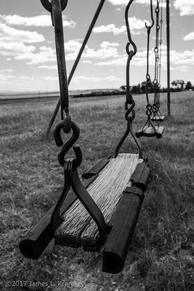 weathered swing set in monochrome by James L. Kramer