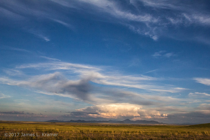 thunderhead over or beyond distant peaks in Montana, by James L. Kramer