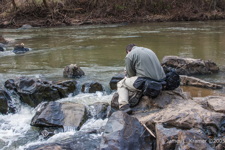 Al Denelsbeck hunched over a photo in the making in the Haw River