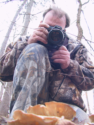 James L Kramer taking photo of mushroom, seen from below the cap