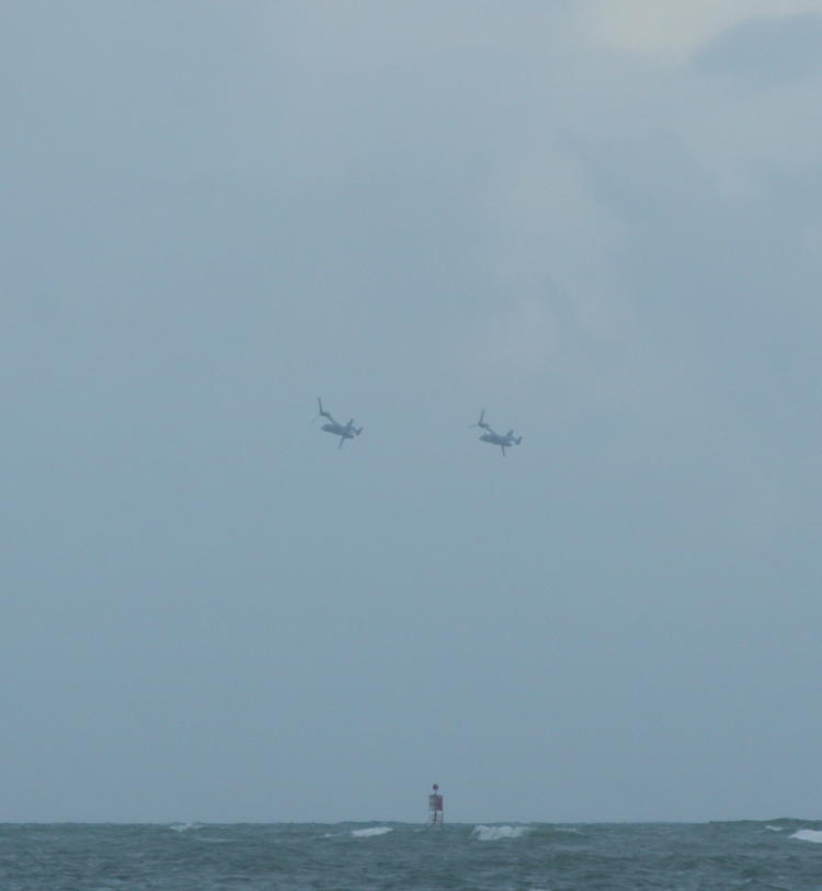 a pair of V-22 Ospreys banking towards closer approach