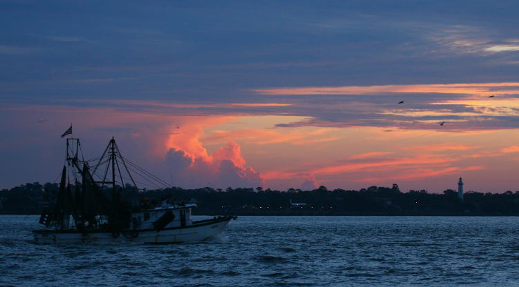 fishing boat in front of St Simons lighthouse, Jekyll Island, Georgia