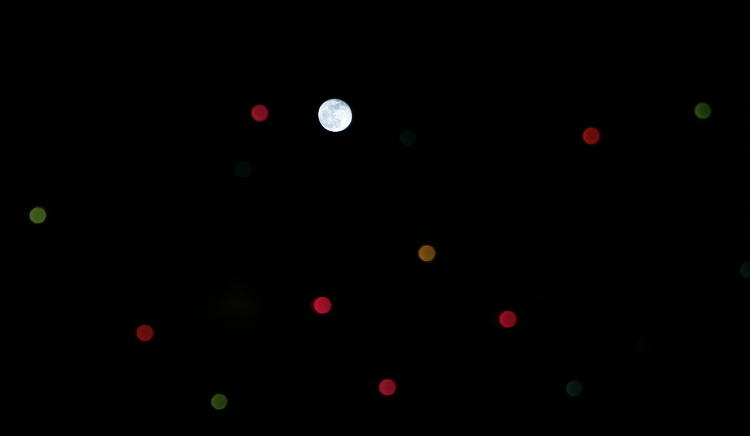 moon alongside defocused christmas lights