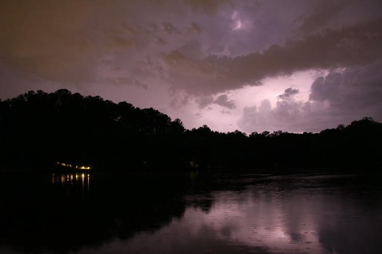 big lightning strike illuminating clouds while invisible