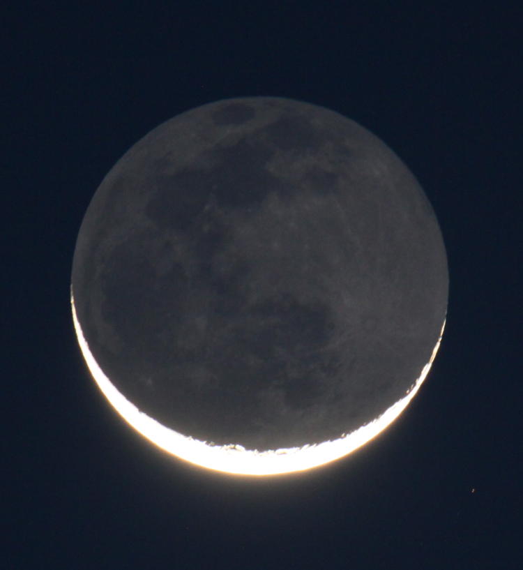 five-percent waning crescent moon showing morning earthshine and lightening skies