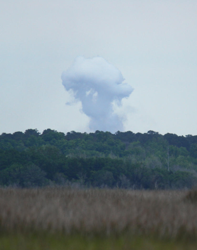 rising white mushroom cloud from military exercises