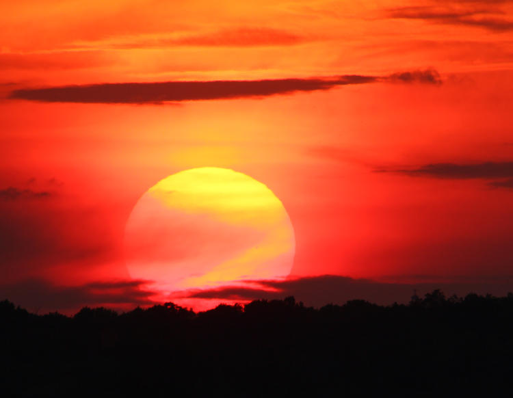 sunset through thin clouds over Cayuga Lake, New York