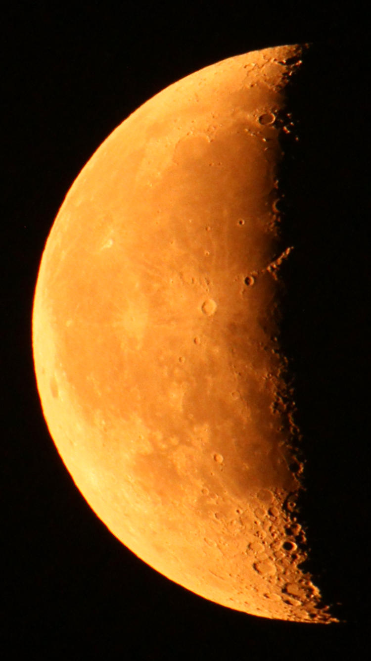 orange waning crescent moon with no light on Tycho's central peak