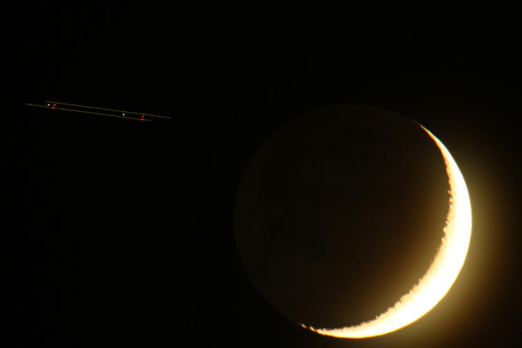 crescent moon with approaching aircraft lights