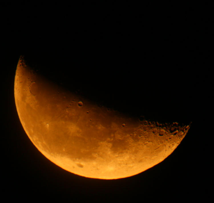 orange waning moon just slightly under half