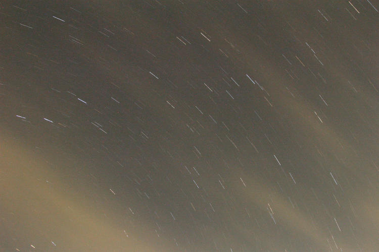star trails time exposure with scattered clouds