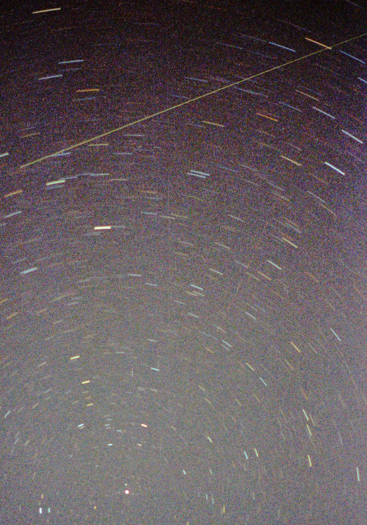 inset of long exposure of star trails showing meteor and aircraft