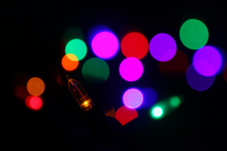 holiday lights in darkness, mostly defocused into bokeh