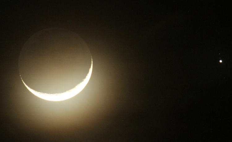 crescent moon overexposed to bring out earthshine as well as Jupiter's moons