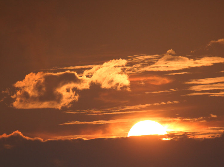 sun breaking above clouds long after astronomical sunrise