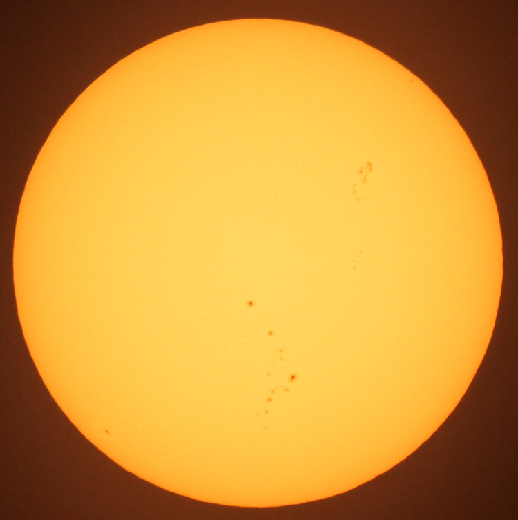 sun through solar filter film showing distinct sunspots