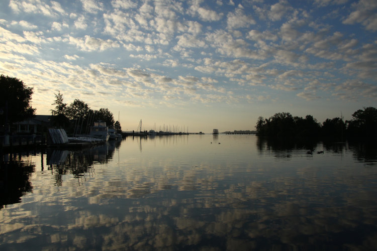 scattered clouds across waterfront at sunrise