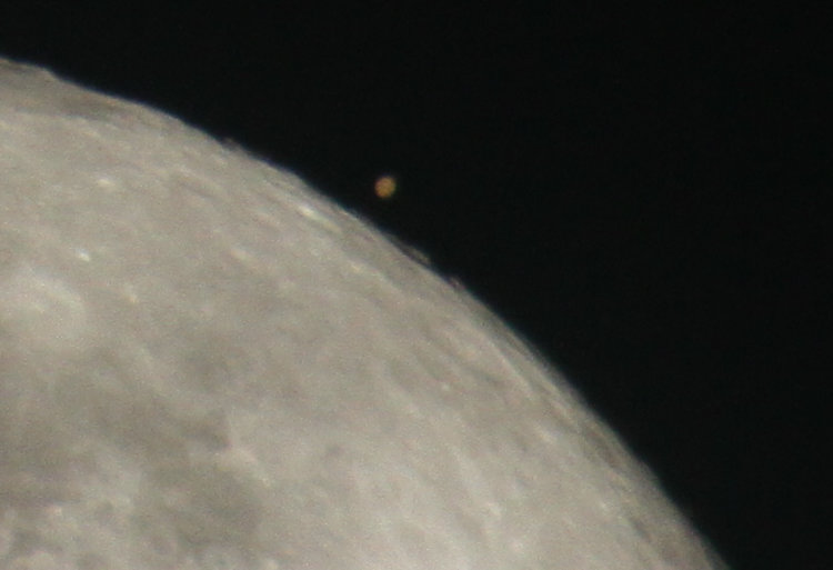 Mars near the moon after reappearing following occultation, partially obscured by cirrus clouds