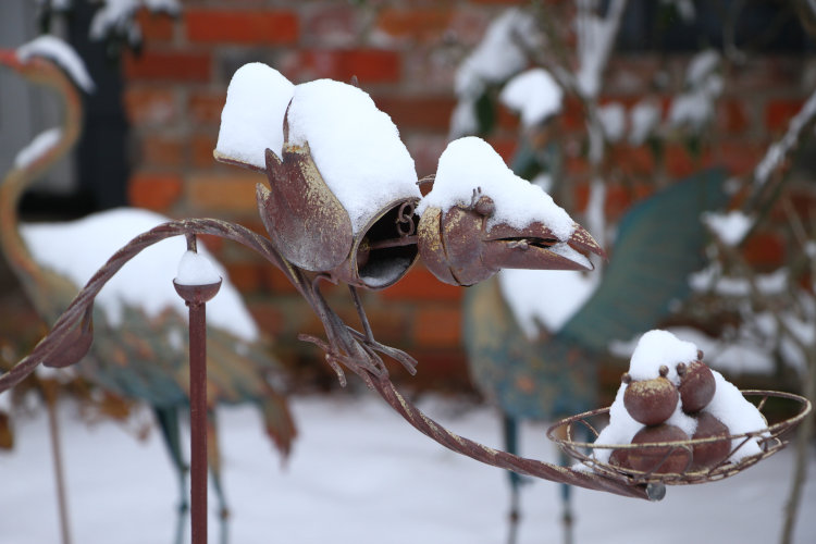 bird nest balance sculpture almost hidden under snow