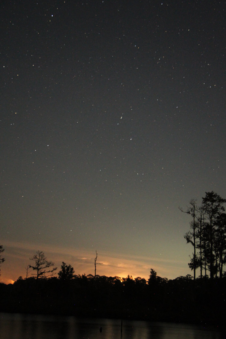 night time exposure showing growing thunderhead with clear skies above