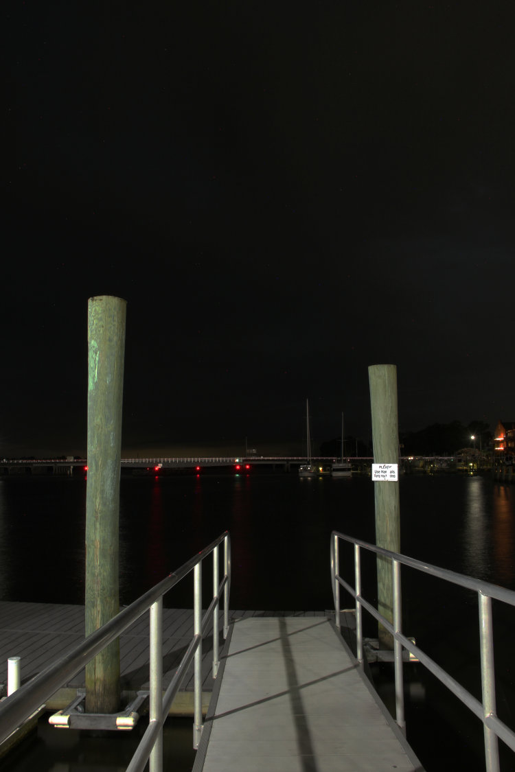 view down onto small dock between lightning bursts