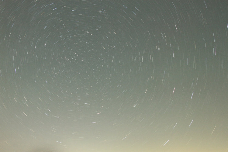 15-minute time exposure of night sky looking north proscribing arcs around Polaris