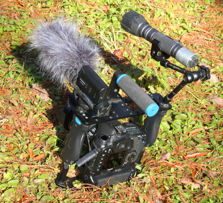 view of DSLR video cage with external microphone and flashlight for night videography