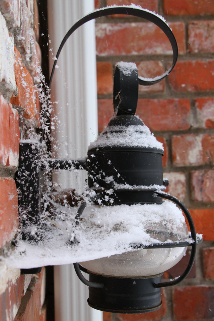 lamp on back porch with webbing from funnel weaver spiders catching snowflakes
