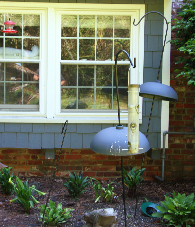 multiple bent-over crooks and a damaged bird feeder from bear marauding