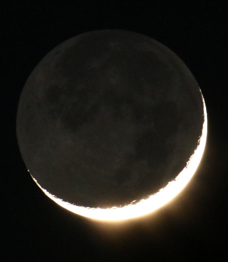 7.4% crescent moon with earthshine and hint of clouds