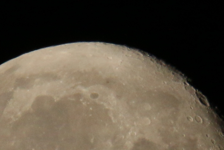 Nearly full moon with smudge of Tiangong space station roughly centered