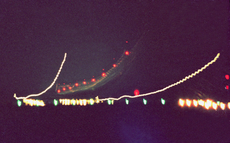 scan of old negative of time exposure of plane landing at night, with notable vibration from cheap tripod in the breeze.