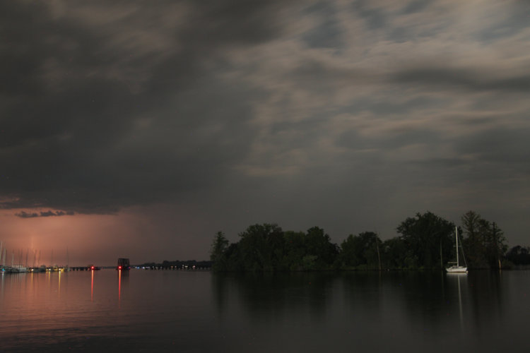 distant lightning strike over Pamlico River with light from moon and waterfront lights