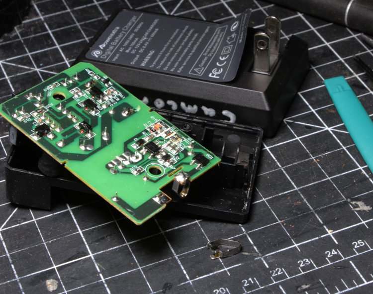 opened battery charger with loose metal contact at bottom
