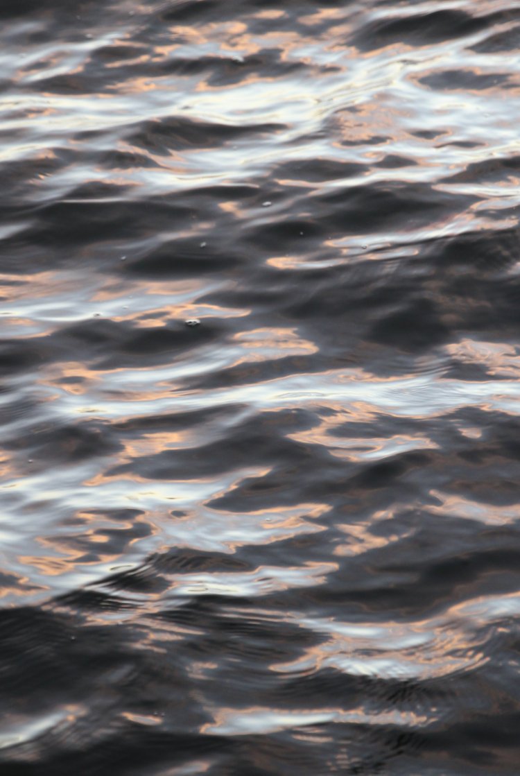thin twilight colors reflected in dark waters after sunset
