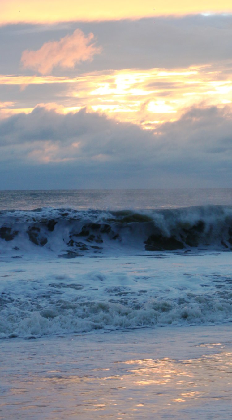 ocean breakers against mostly-clouded sunrise