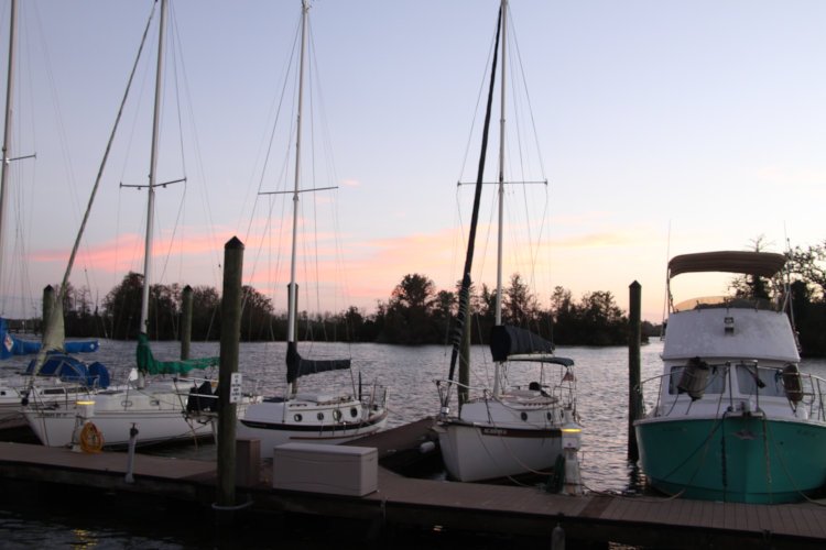 post-sunste pastel colors behind boats at dock on waterfront
